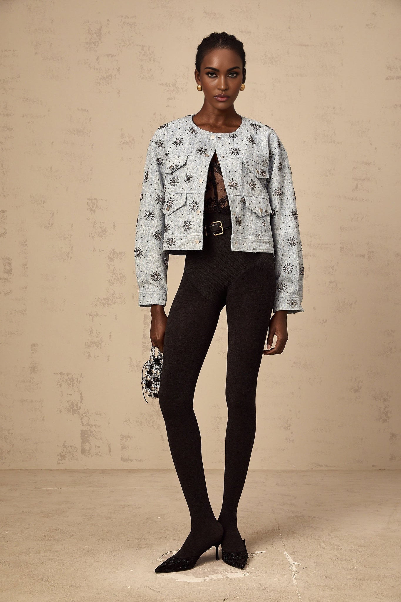 A blue denim jacket with sun motif studs decorating the fabric Katell brand visible on the garment