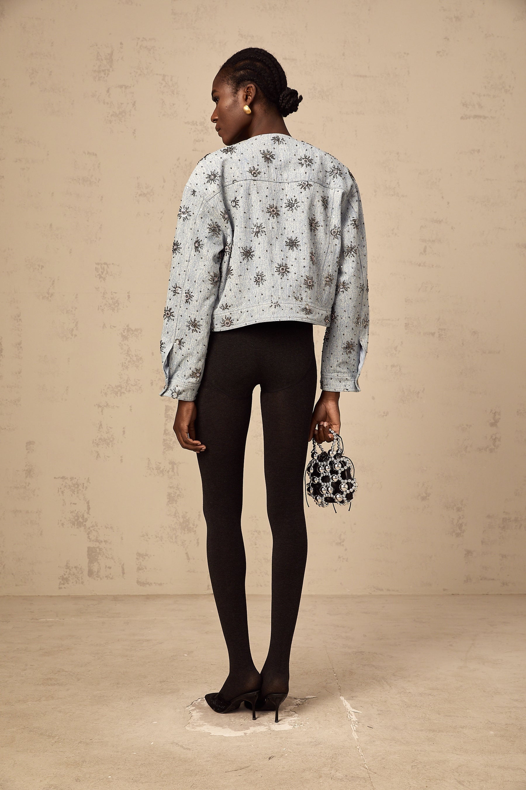 A blue denim jacket with sun motif studs decorating the fabric Katell brand