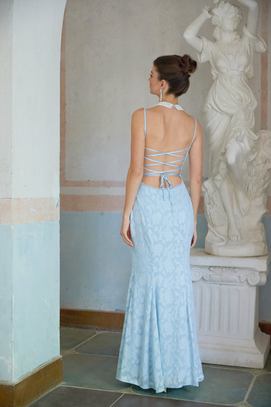A blue flared maxi dress with laceup detail and jacquard pattern on a female model