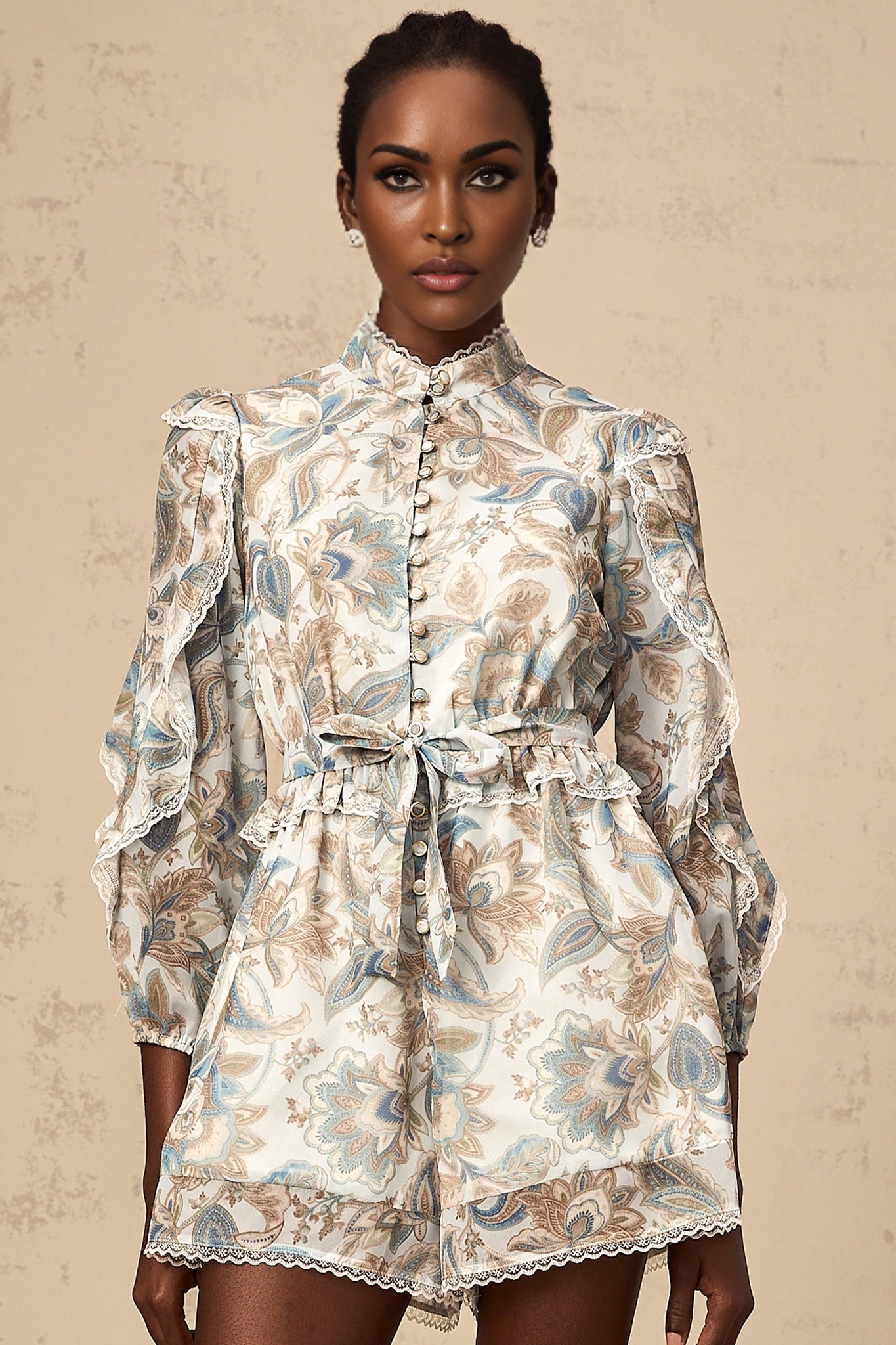 A blue floral print jumpsuit with ruffles and lace trim details named Eugenie