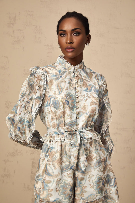 A blue floral print jumpsuit with ruffles and lace trim named Eugenie