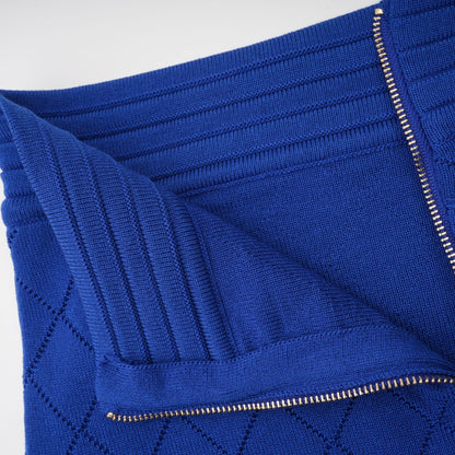 A blue knitted matching set featuring a top and skirt with button details The top has a fitted silhouette while the skirt is flared Both pieces are made from a textured knit fabric in a vibrant blue color