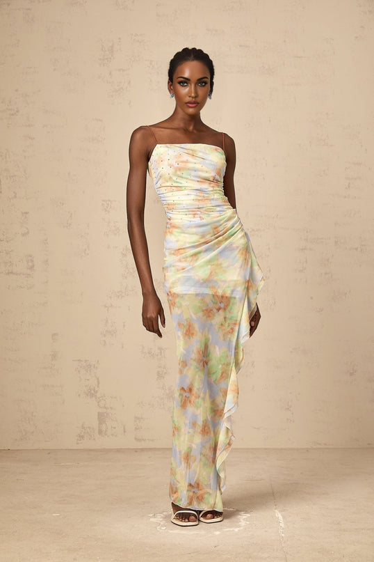 A blue maxi dress with an asymmetric design featuring a floral print pattern and ruched detailing named Yseult