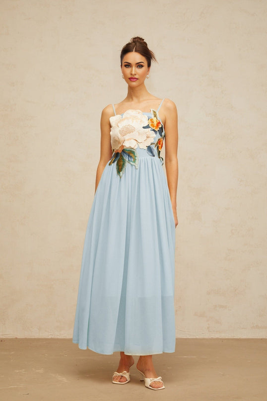 A blue maxi dress with floral embroidery and shirred detailing named Josette