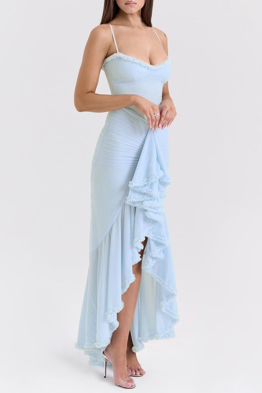 A blue maxi dress with ruffle details and draped fabric featuring a long flowing silhouette