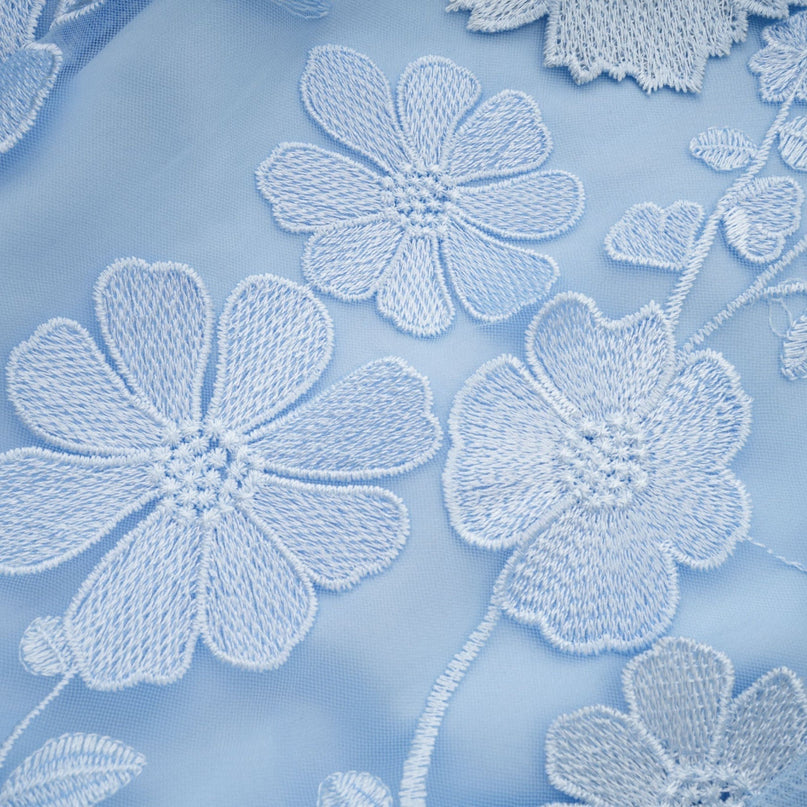 A blue midi dress featuring floral appliques on the fabric Herta design with feminine silhouette and delicate floral embellishments