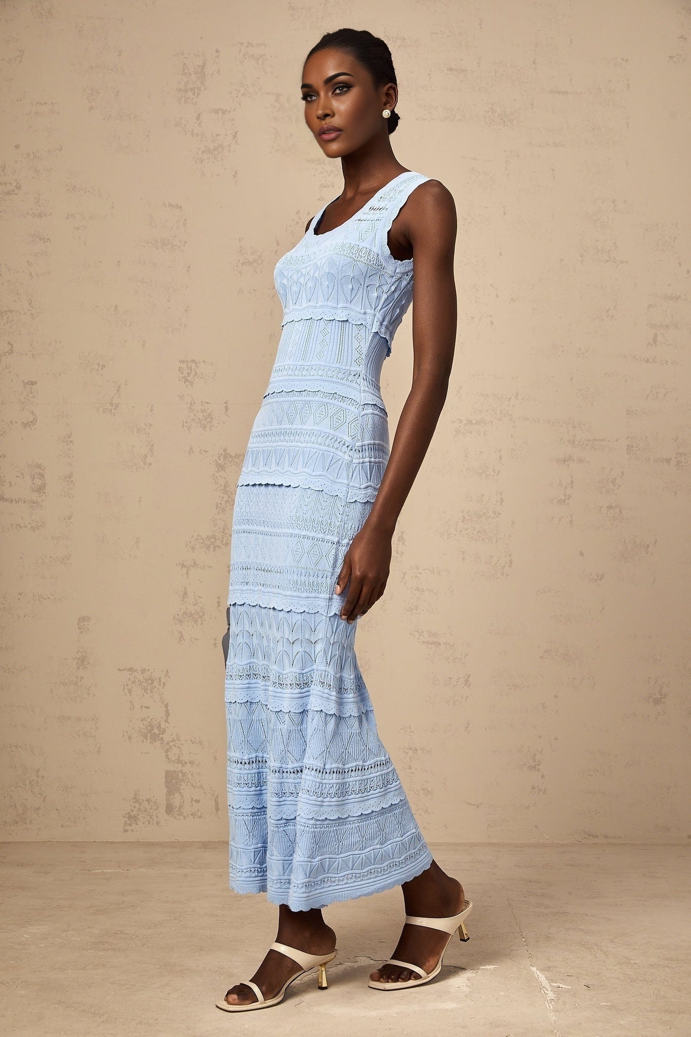 A blue midi dress with a crochet knit pattern featuring ruffled trim details and a feminine silhouette