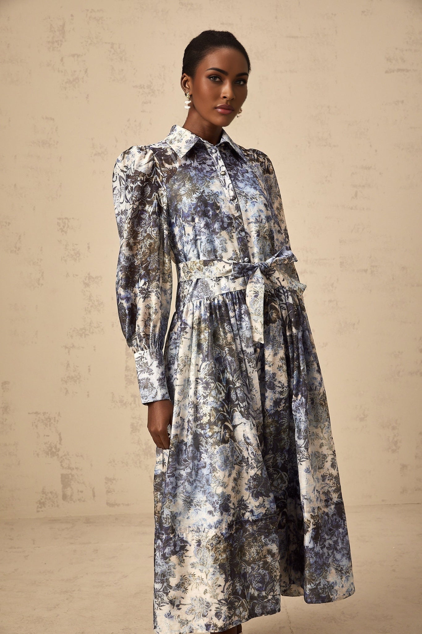 A blue midi dress with a floral print pattern named Irina displayed on a plain background