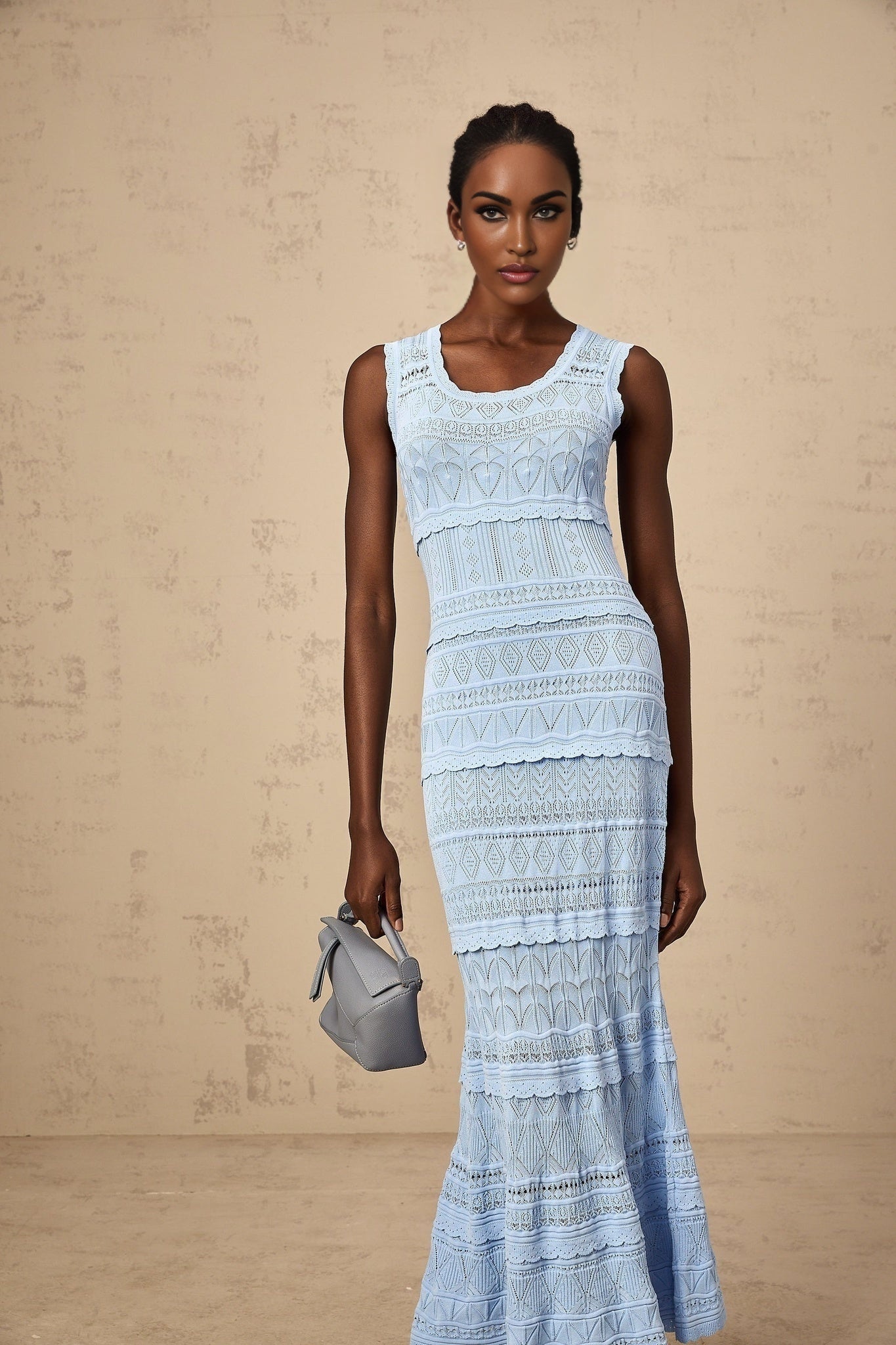 A blue midi dress with ruffled trim and crochet knit details featuring a feminine silhouette and delicate texture
