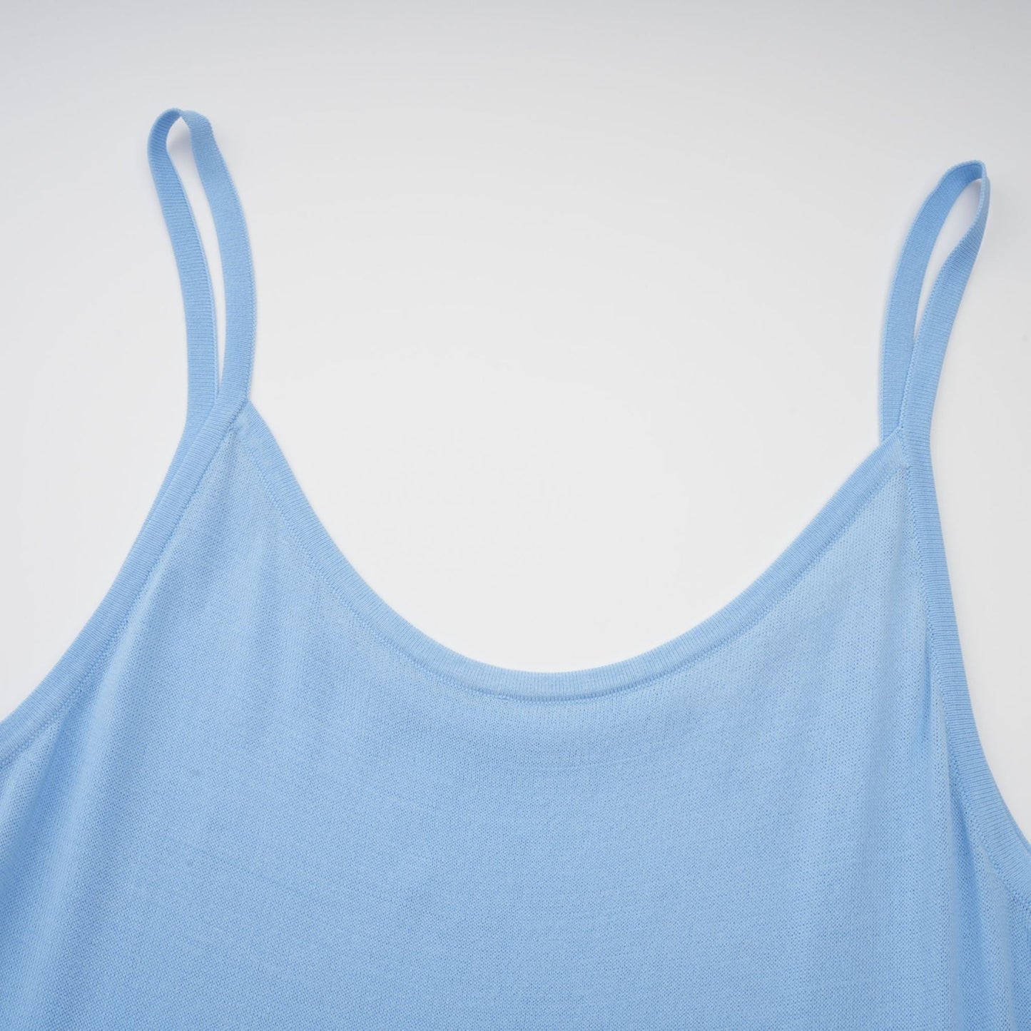 A blue midi dress with ruffled trim and crochet knit pattern worn by a model standing in a neutral setting