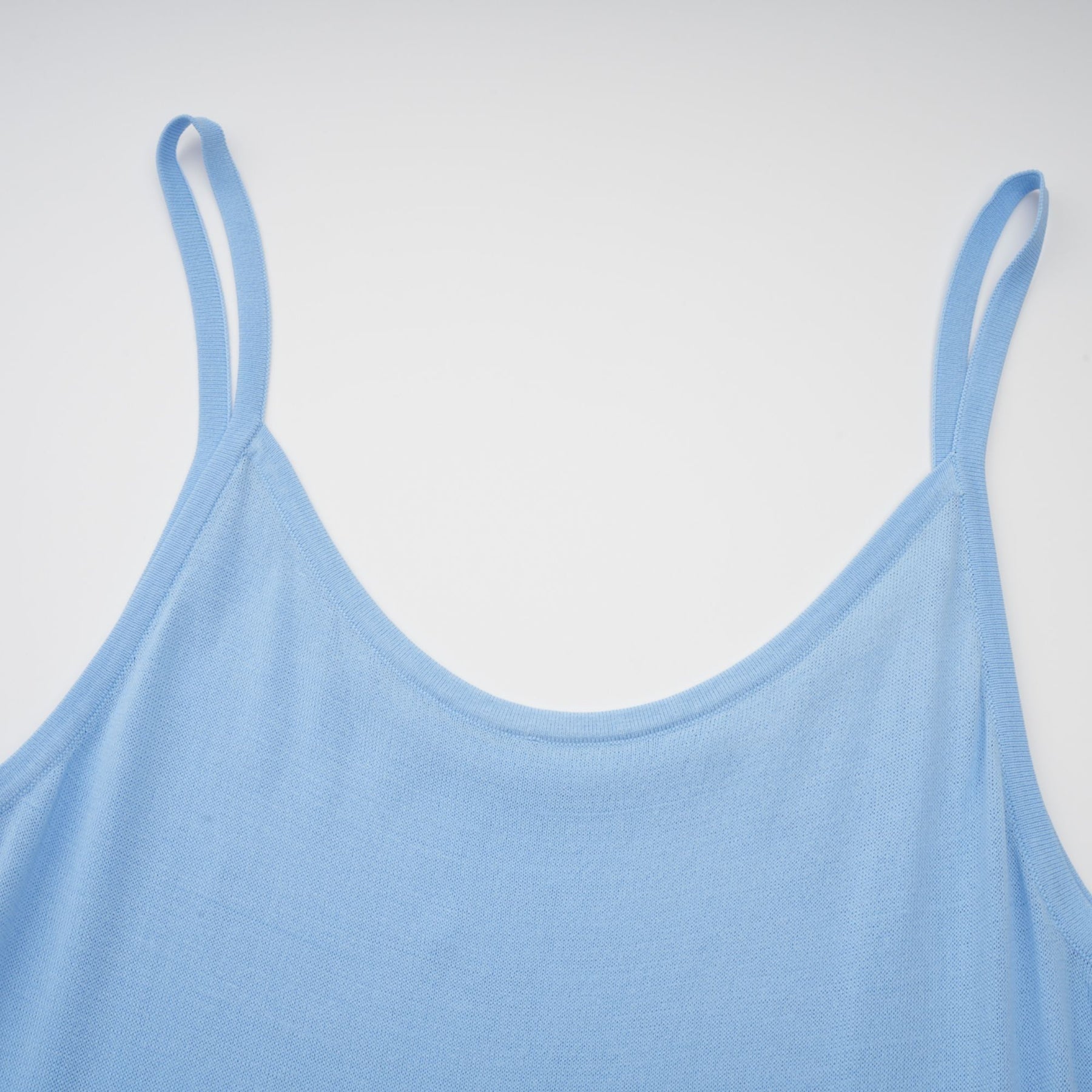 A blue midi dress with ruffled trim and crochet knit pattern worn by a model standing in a neutral setting