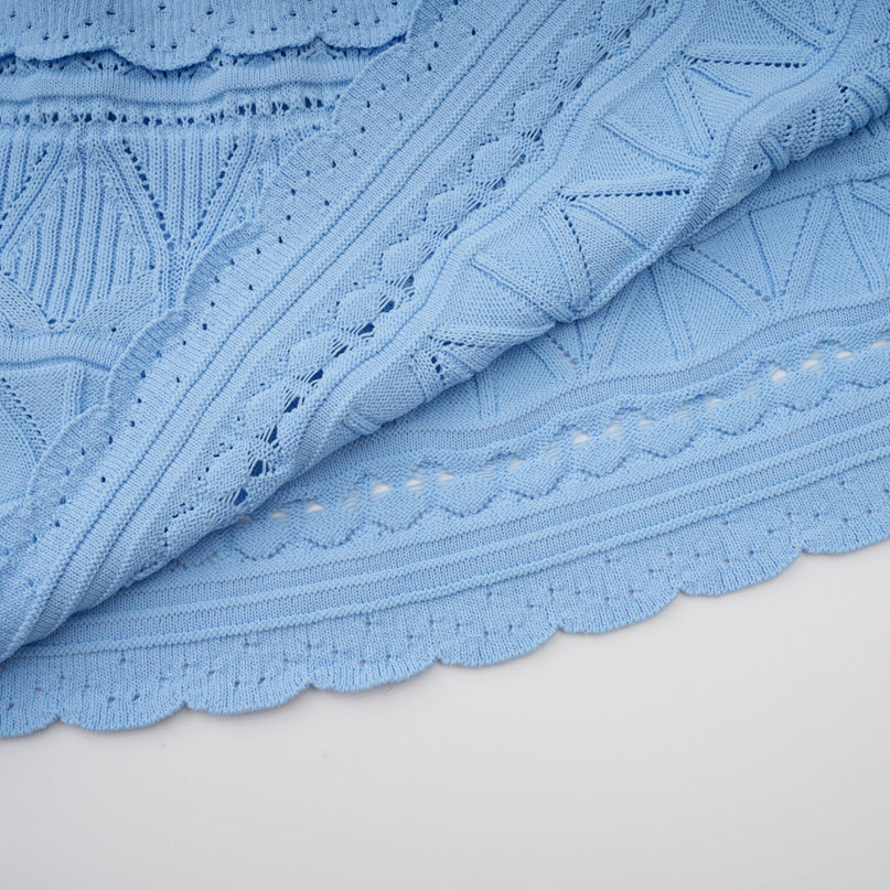 A blue midi dress with ruffled trim and crochet knit texture featuring a sleeveless design and fitted silhouette