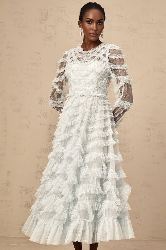 A blue midi dress with small white dots and ruffled details named Adelaide