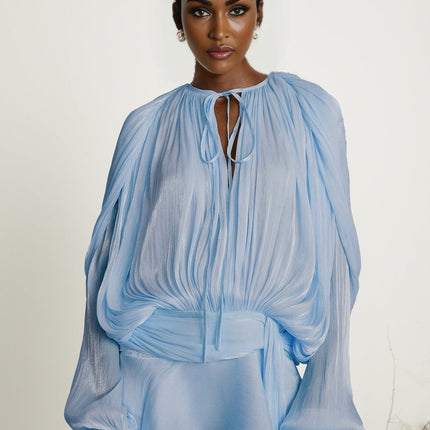 A blue mini dress with full pleats and ruffles called the Eugenie featuring a short hemline and feminine details