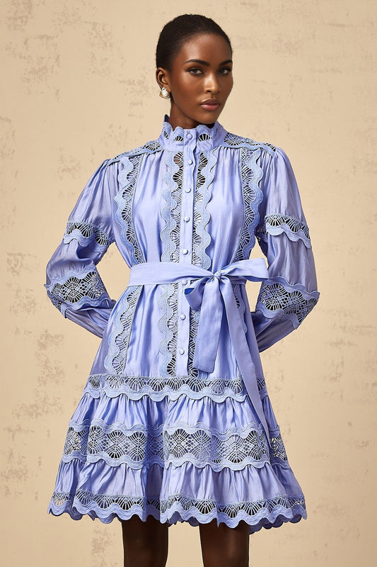 A blue mini dress with tiered layers featuring cut out embroidery patterns Poema brand short dress with intricate detailing and a flowy silhouette