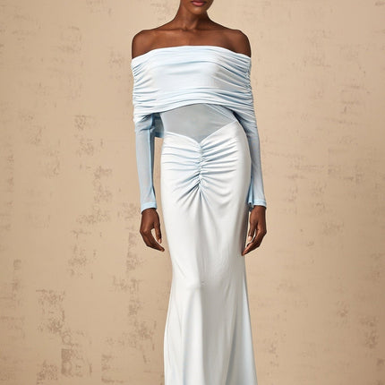 A blue offshoulder maxi dress with ruched detailing named Ninon worn by a model against a plain background