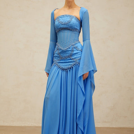 A blue pleated maxi dress with faux pearl embellishments by Gaelle