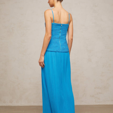 A blue pleated maxi dress with side slits and a flowing silhouette