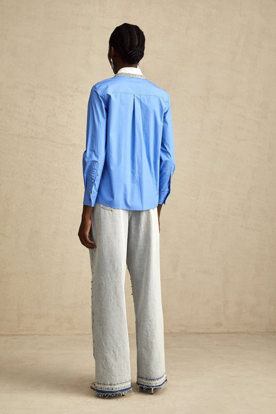 A blue shirt with a color block design featuring rhinestone embellishments named Émilie