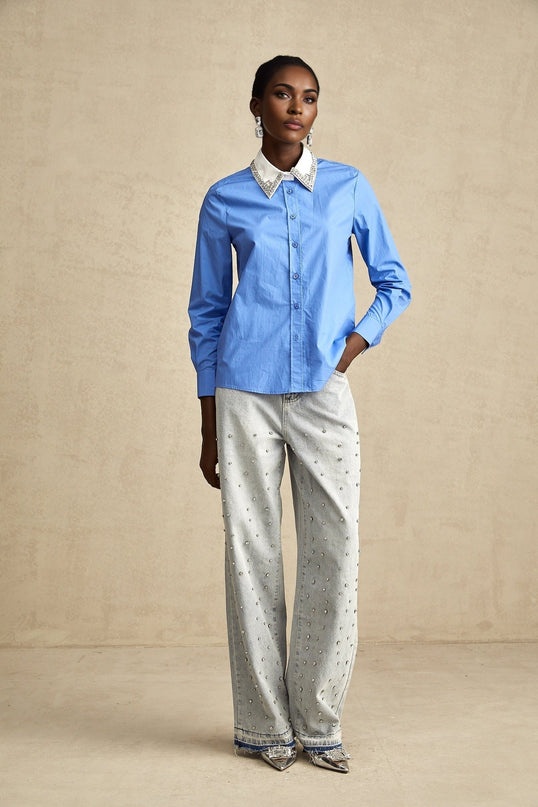 A blue shirt with color blocked sections and rhinestone embellishments called Émilie