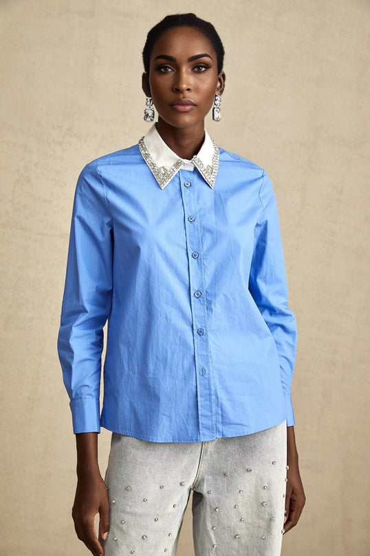 A blue shirt with rhinestone embellishments and contrasting color blocks featuring a design named Émilie