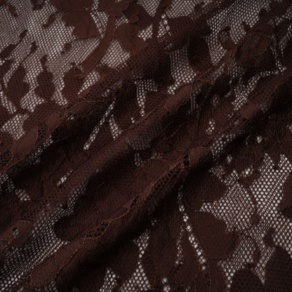 A brown flared midi dress made of chantilly lace named Sylvie featuring delicate floral patterns and a feminine silhouette