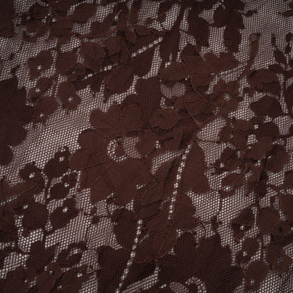 A brown flared midi dress made of chantilly lace named Sylvie hanging on a hanger against a plain background