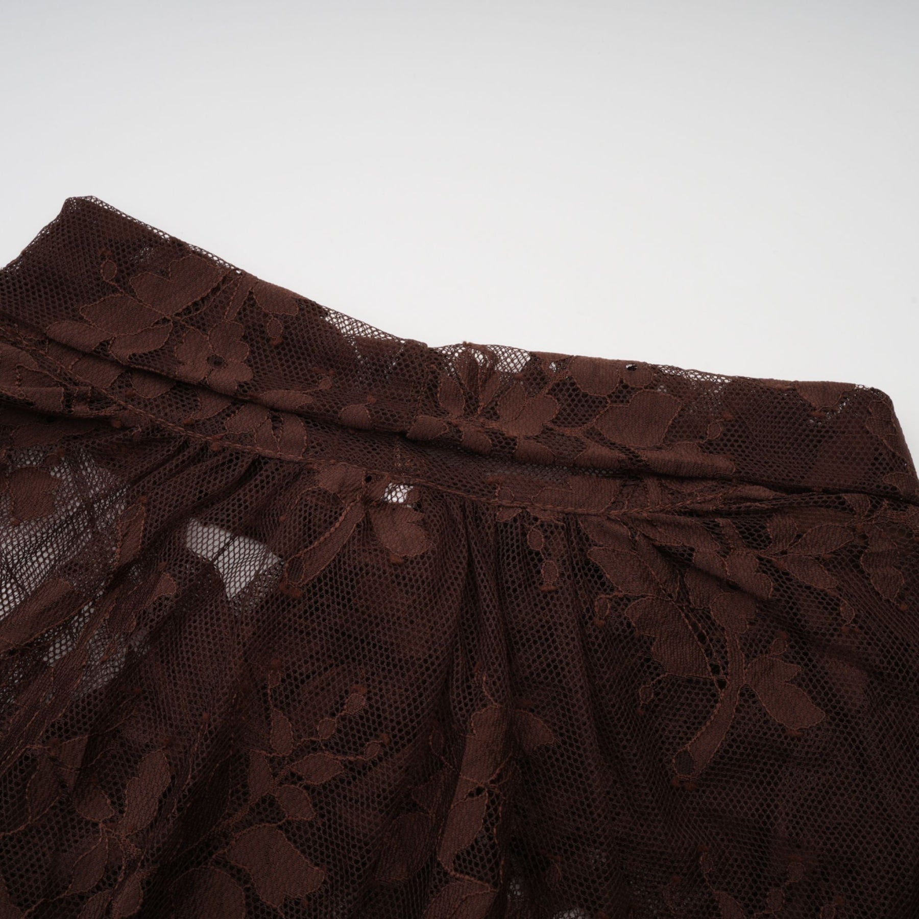 A brown flared midi dress made of chantilly lace named Sylvie with delicate floral patterns and a flattering silhouette