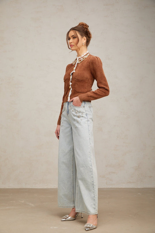 A brown knit cardigan with ruffled details and embellishments worn by a model named Elisabetta