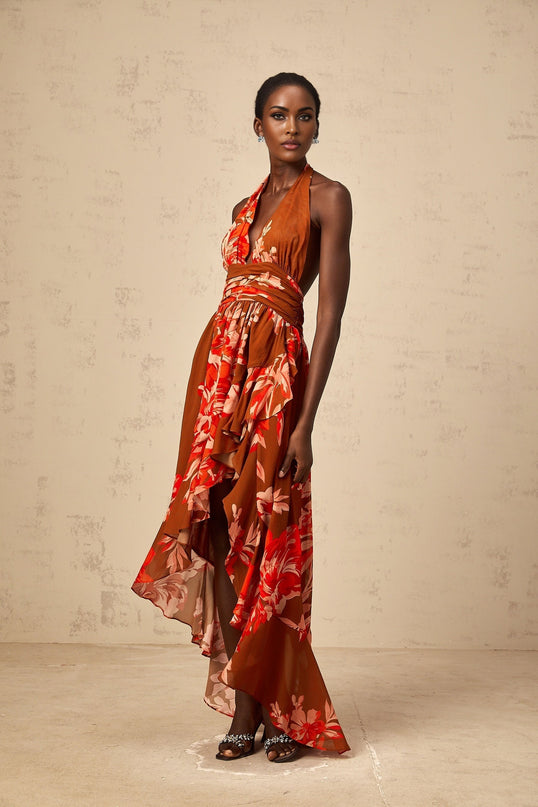 A brown maxi dress with floral print and asymmetrical design featuring a long flowing skirt and Angelique style