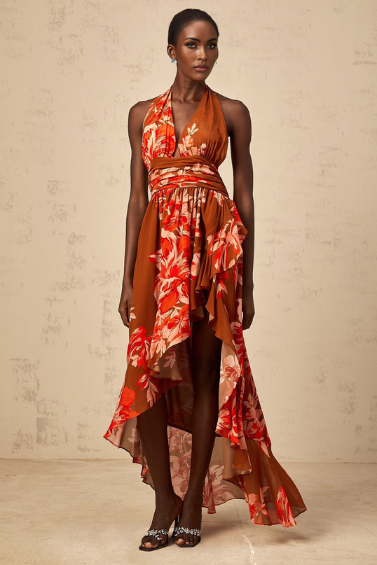 A brown maxi dress with floral print and asymmetrical hemline featuring long sleeves and a flowy silhouette