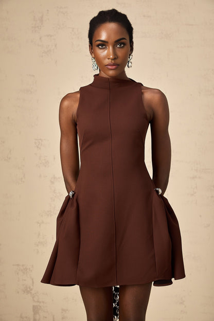 A brown mini dress with an asymmetric neckline and puff sleeves worn by a model named Dora