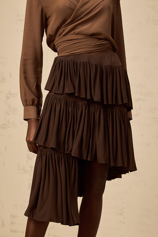 A brown mini skirt with asymmetrical pleated tiers and an uneven hemline named Astrid