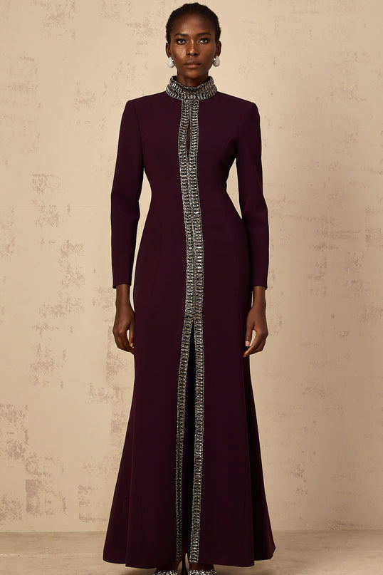 A burgundy colored floorlength maxi dress with flared skirt and embellished details worn by a female model