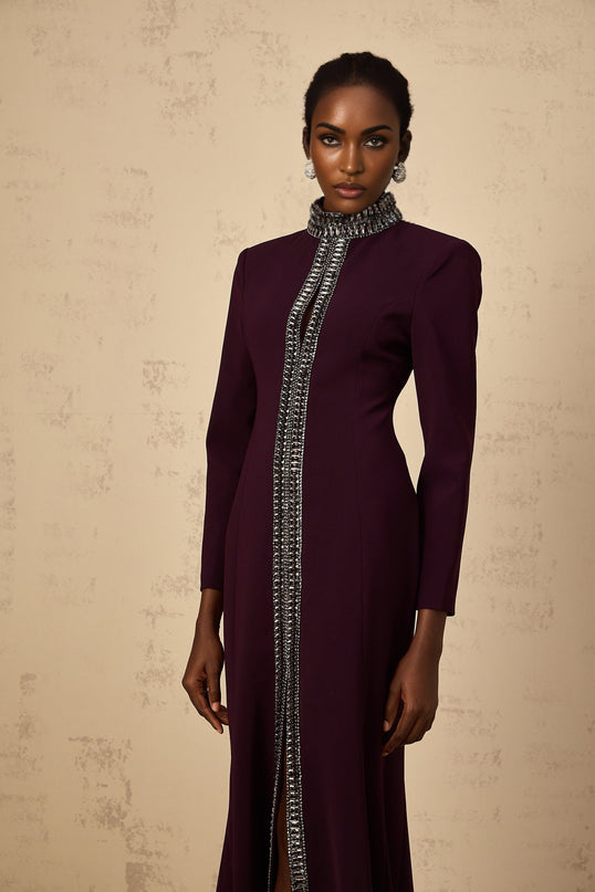 A burgundy maxi dress with flared skirt and embellished details modeled on a woman