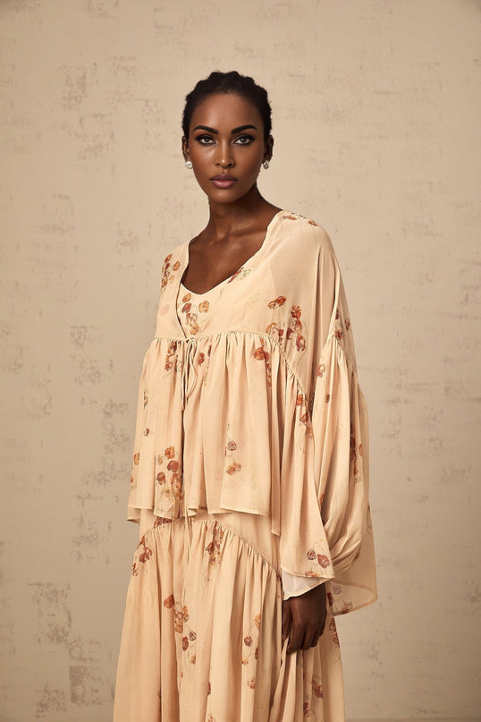 A coralpink floral print matching set featuring a pleated blouse and dress in the Maïa style