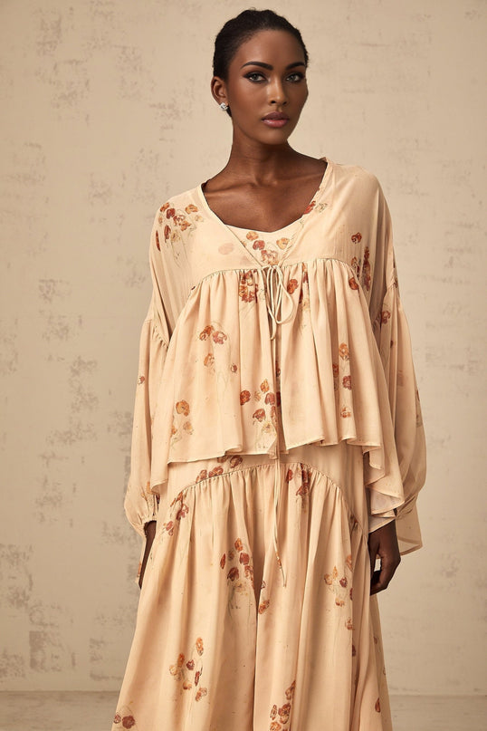 A coralpink matching set featuring a floral print blouse with pleats and a coordinating dress both in a soft feminine style