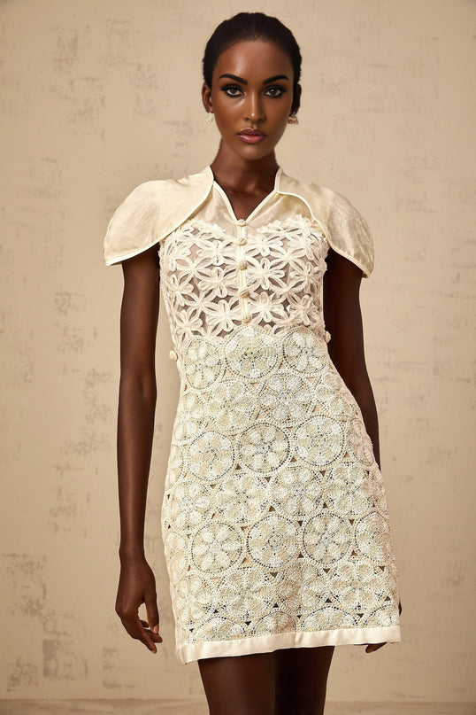 A cream colored mini dress with embroidered details and paneled design named Wilhelmine