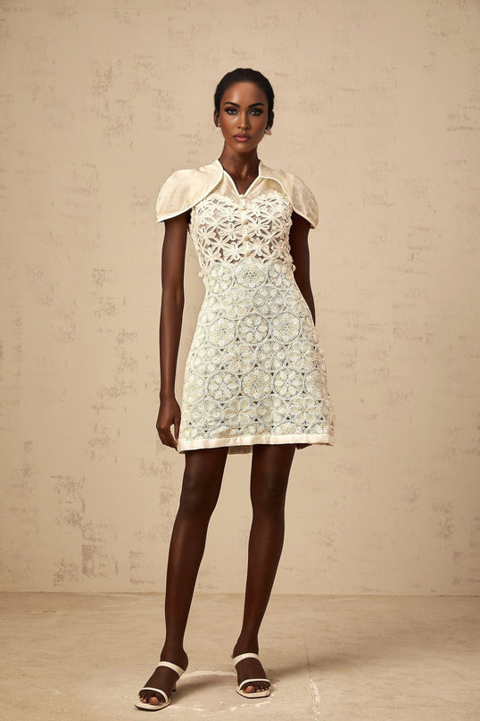A cream colored mini dress with embroidery details and paneled design named Wilhelmine