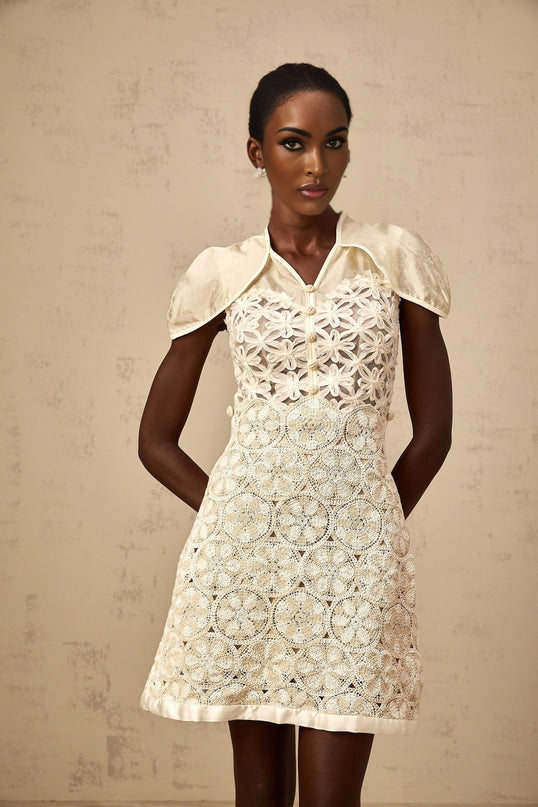 A creamcolored mini dress with embroidered details and panels named Wilhelmine