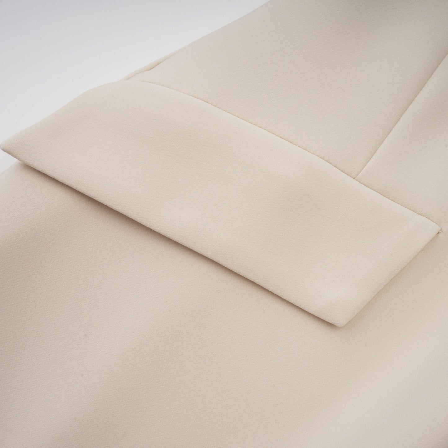 A creamwhite fitted mini dress by Chloe on a plain background showcasing its sleek silhouette and elegant design