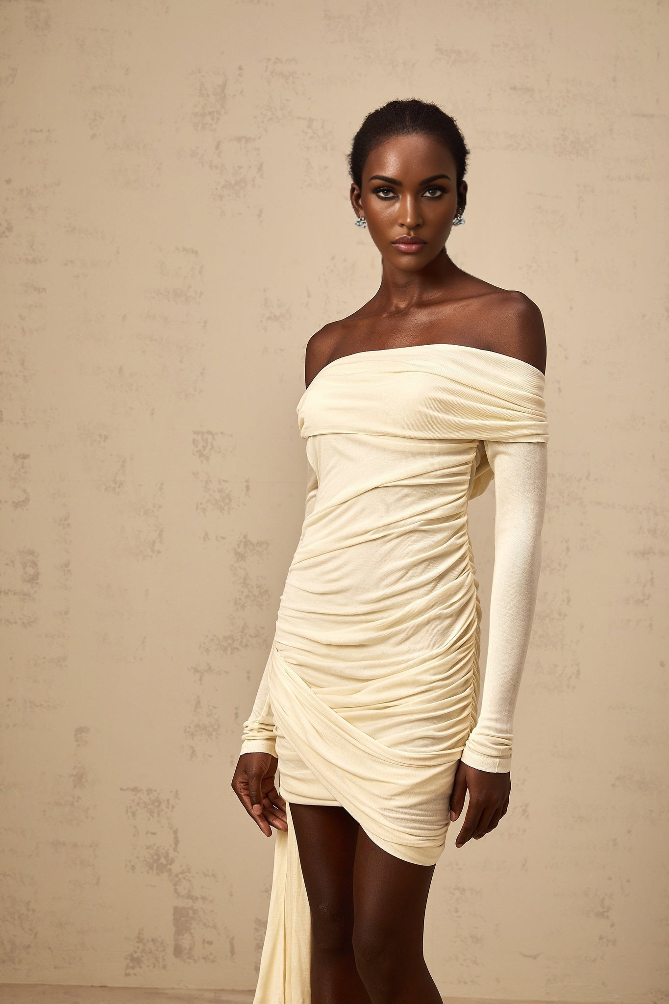 A creamwhite mini dress with ruched detailing and ribbon design called Margaux