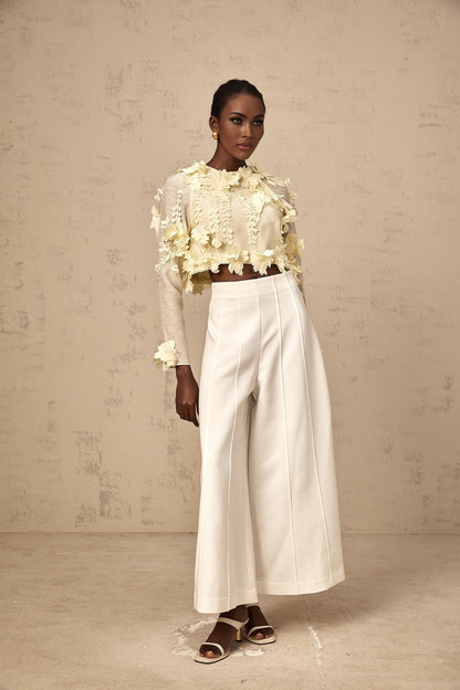 A cropped blouse in light yellow color featuring threedimensional petal details named Rosalie