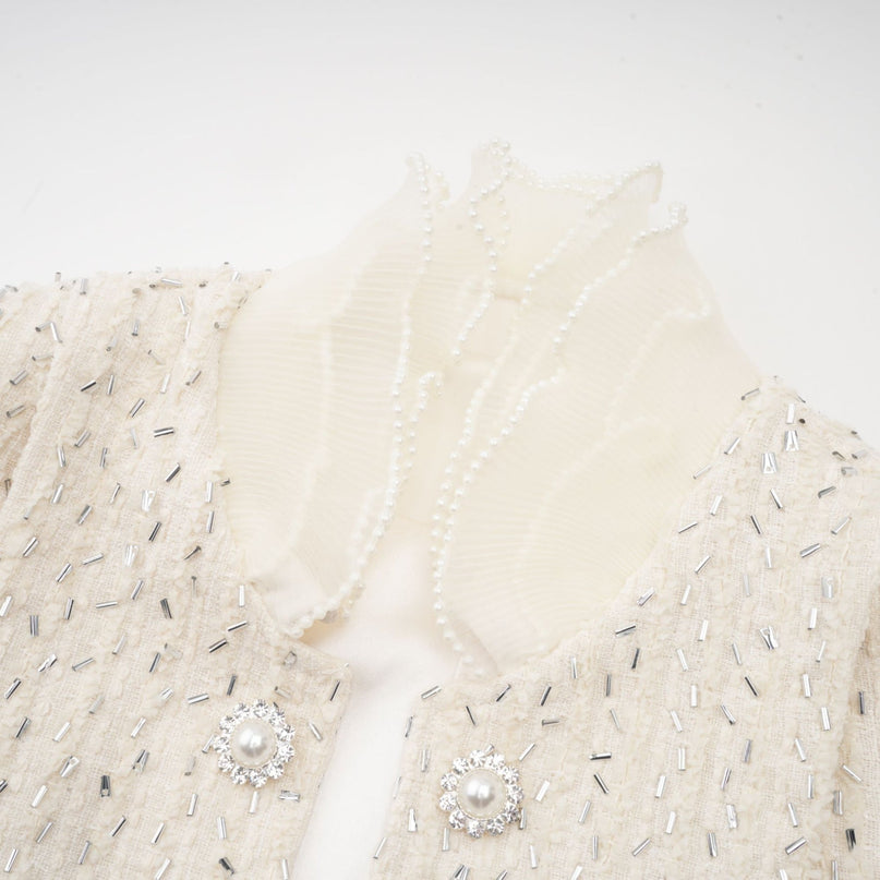 A cropped white jacket with beaded details and ruffle accents named Blanche
