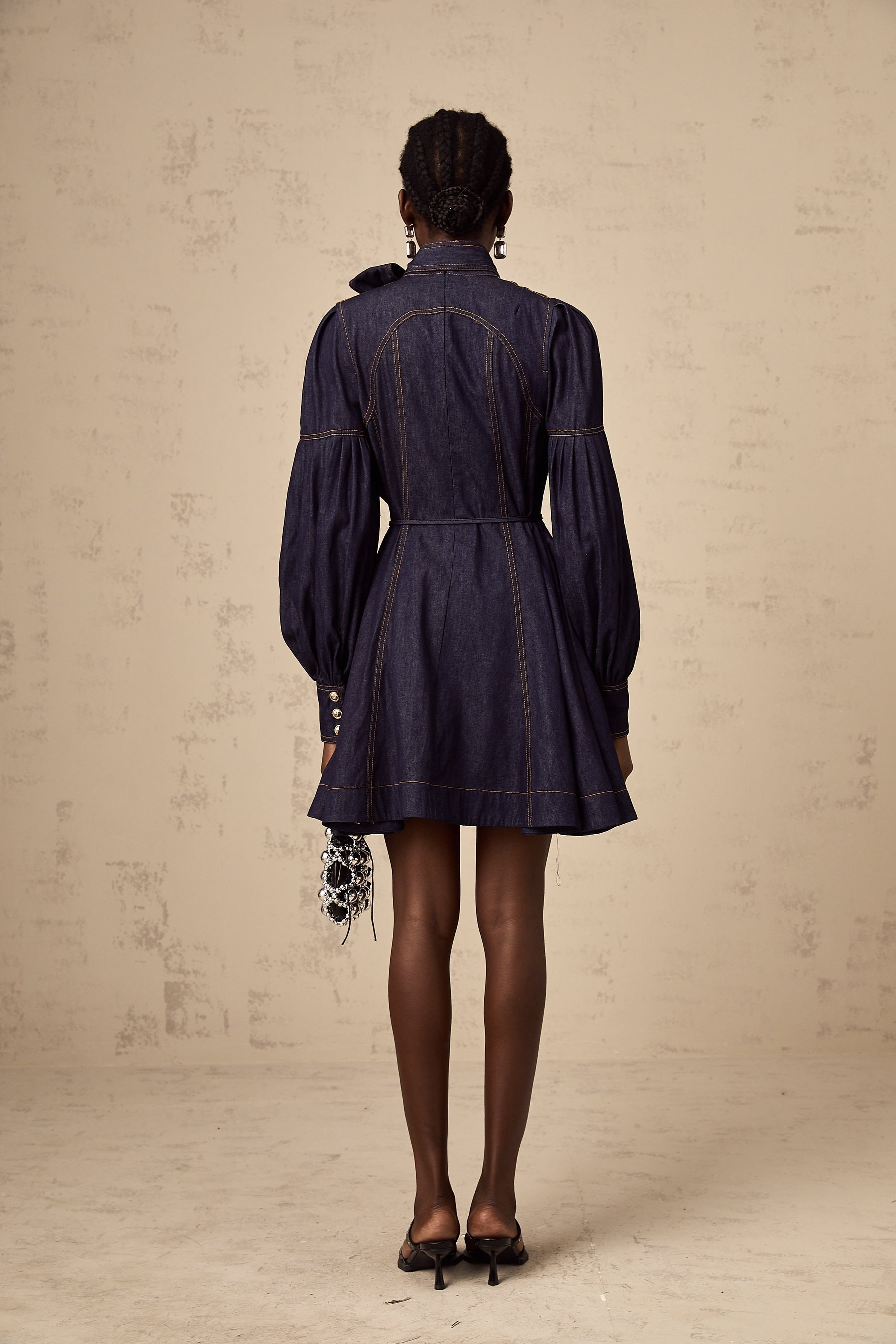 A dark blue denim mini dress with contrasting lightcolored stitching named Mirabel