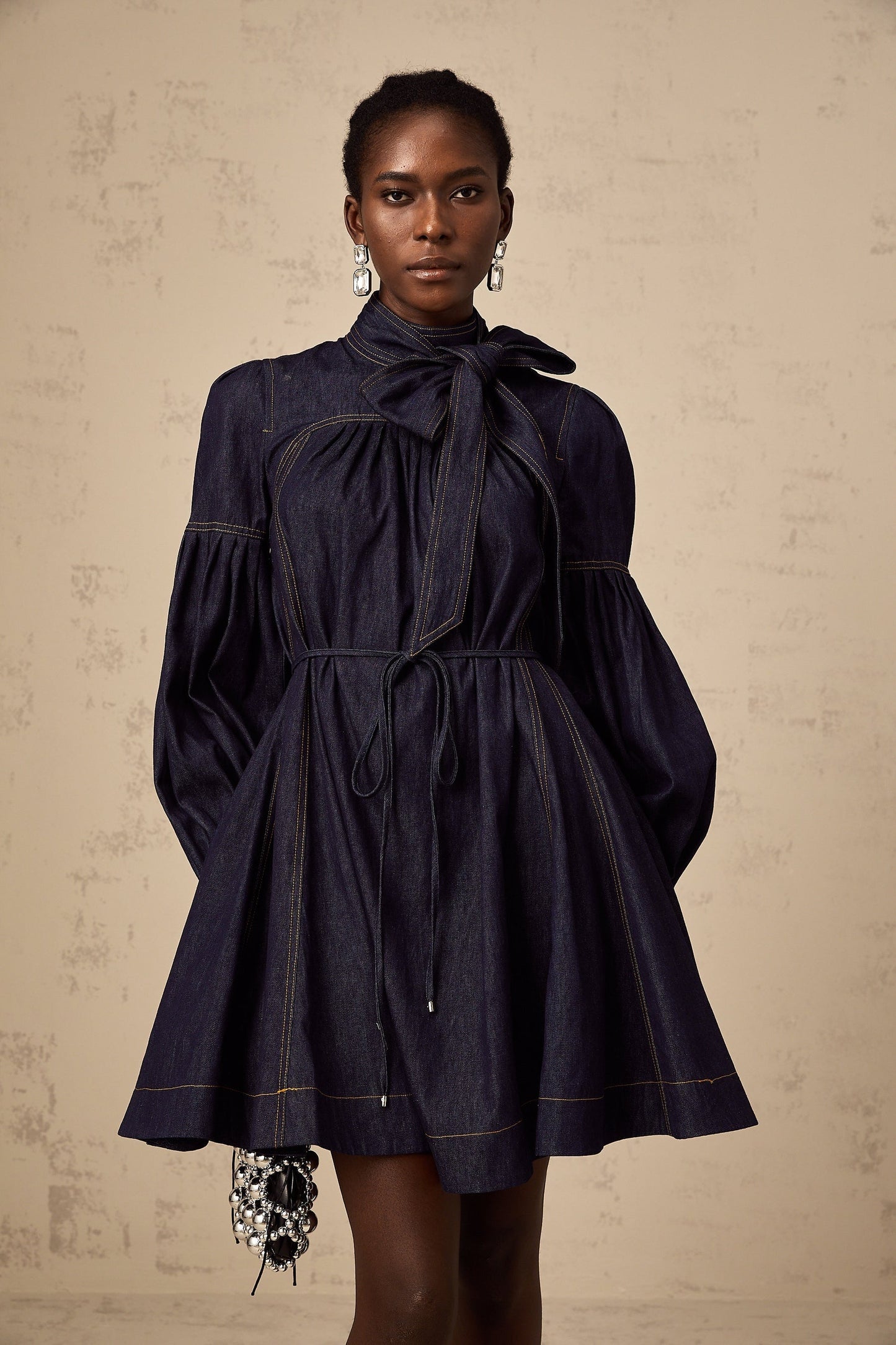 A dark blue denim mini dress with contrasting lightcolored stitching named Mirabel