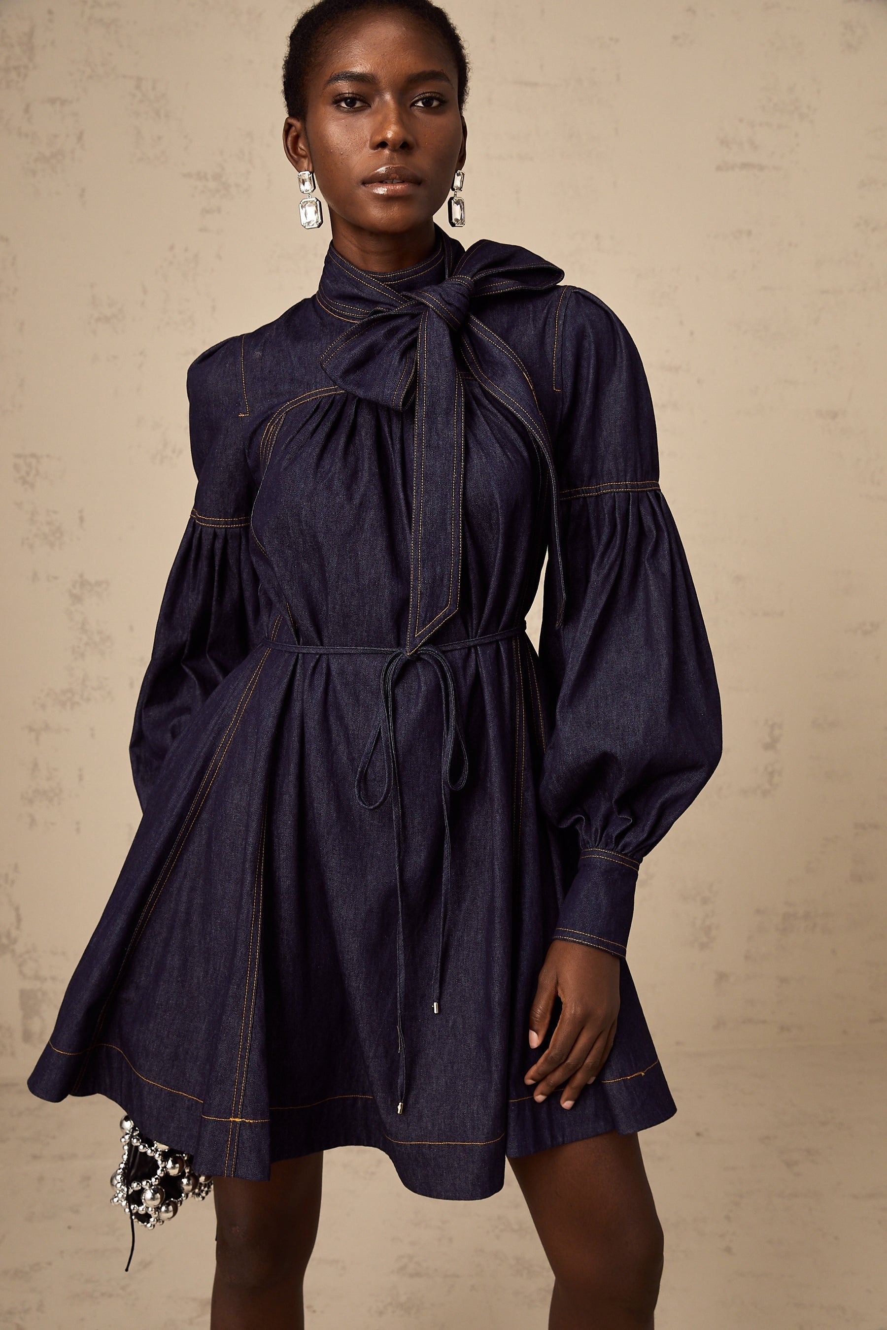 A dark blue denim mini dress with contrasting lightcolored stitching named Mirabel