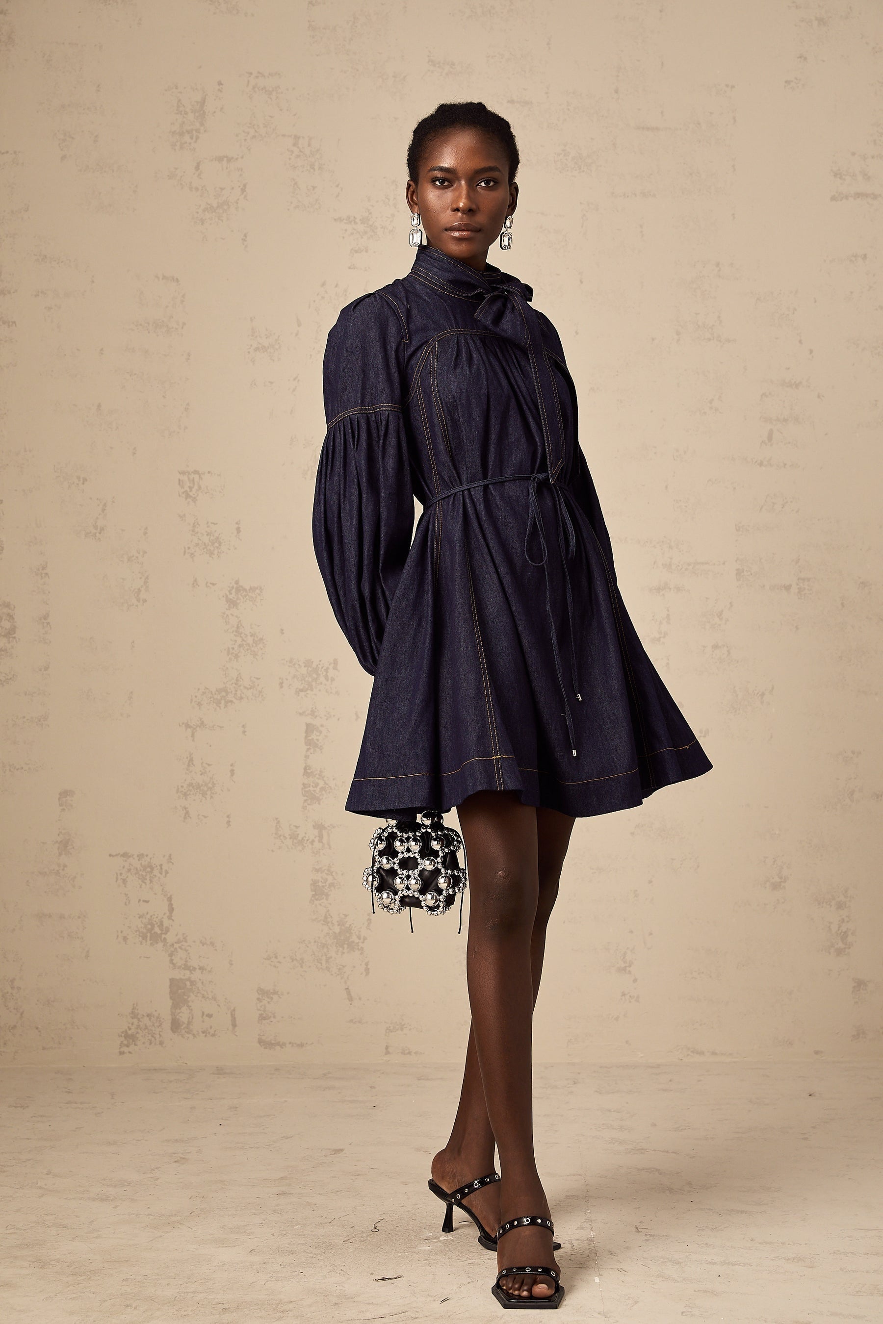 A dark blue denim mini dress with visible contrast stitching details named Mirabel