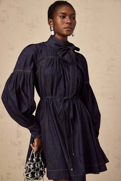 A dark blue denim mini dress with visible contrast stitching named Mirabel