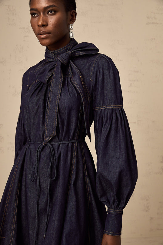 A dark blue denim mini dress with visible contrast stitching named Mirabel